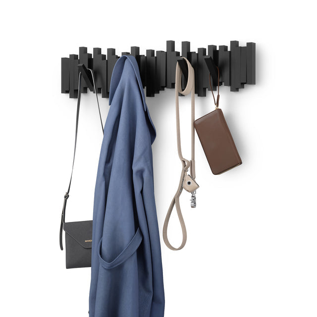 Umbra Sticks 8 hook rack in black holding a blue coat, a shoulder bag and keys