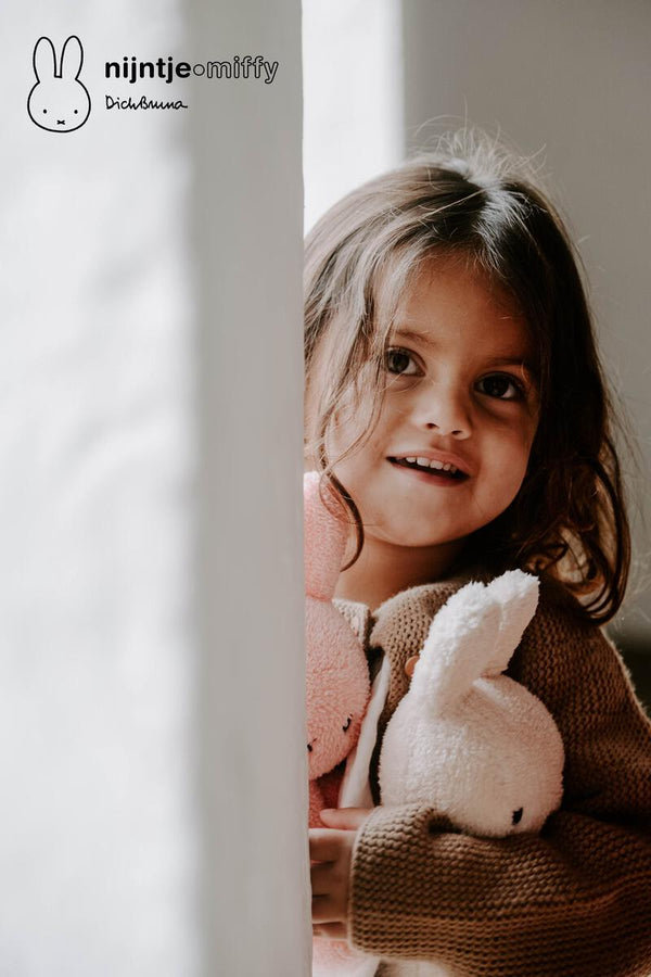 A little girl snuggling a Miffy Sitting Terry Cream (23cm) plush bunny from Mr Maria.