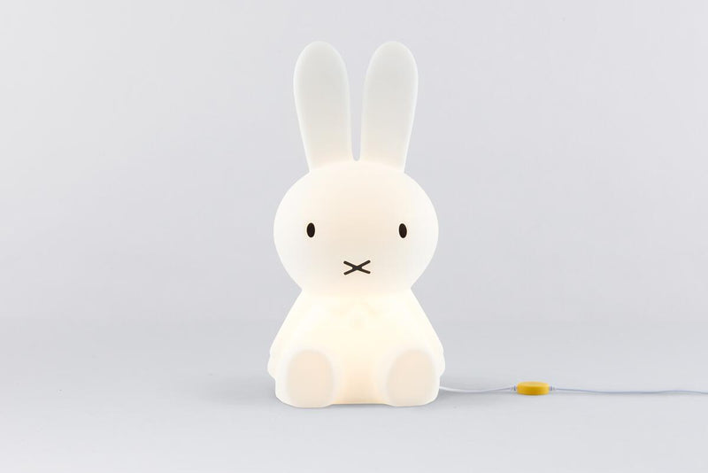 A medium-sized white bunny sitting on a white surface with a Mr Maria Miffy Star Light - DIMMABLE, MOOD LIGHTING.