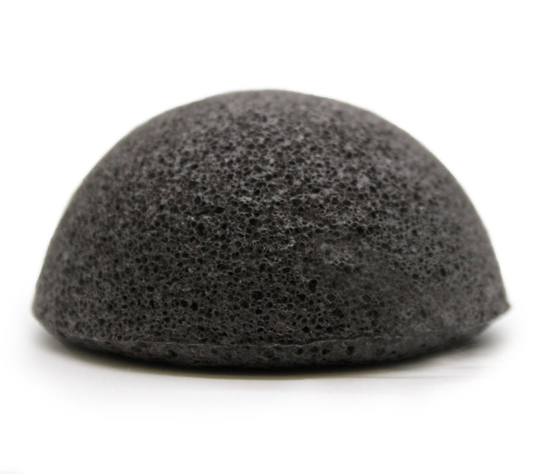 A black Florence Konjac Premium Facial Puff Sponge with Bamboo Charcoal sitting on top of a white surface.
