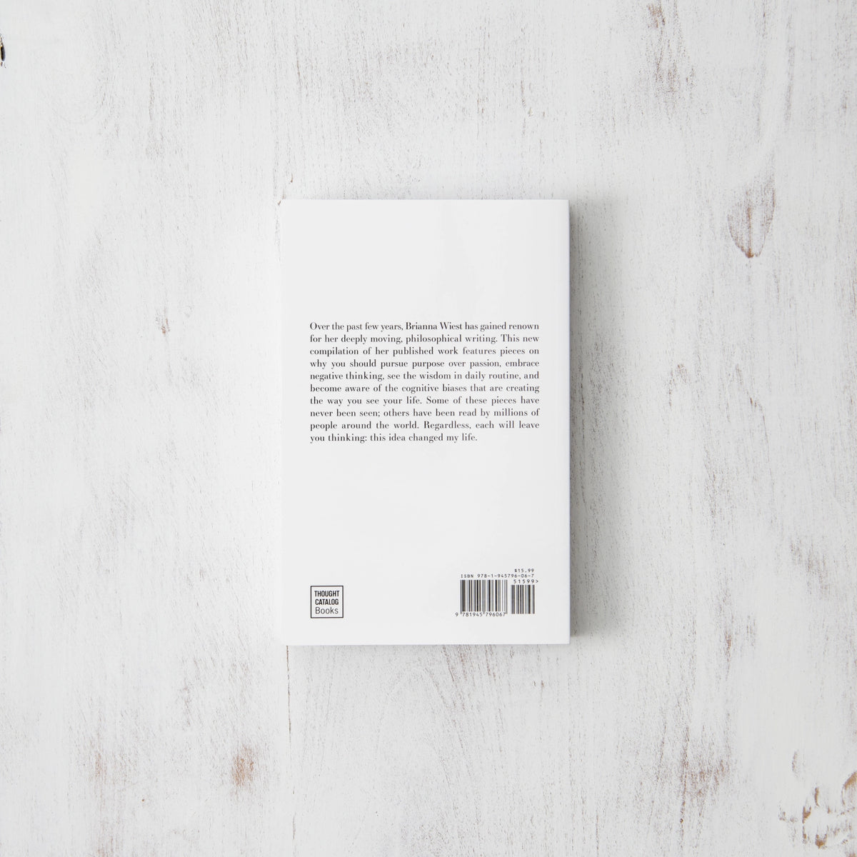 Back cover of the 101 Essays paperback lying on a pale washed timber surface