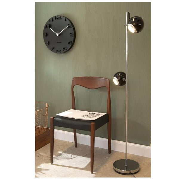 An innovative Karlsson On The Edge Wall Clock - Black (42cm) floor lamp with a wall clock.