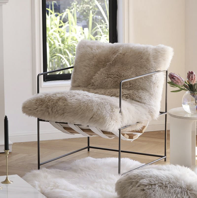 A Sheepskin Occasional Chair with NZ Sheepskin by Flux Home in a living room.