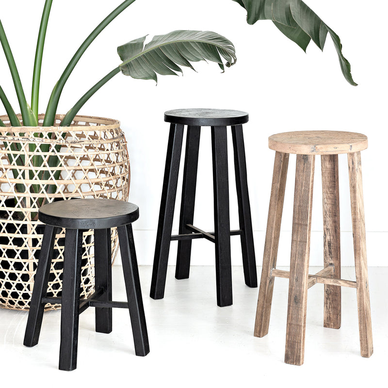 Three Flux Home TEAK BAR STOOL NATURAL - 65cm stools next to a potted plant.