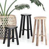 Three TEAK ROUND STOOL NATURAL stools next to a potted plant, by Flux Home.