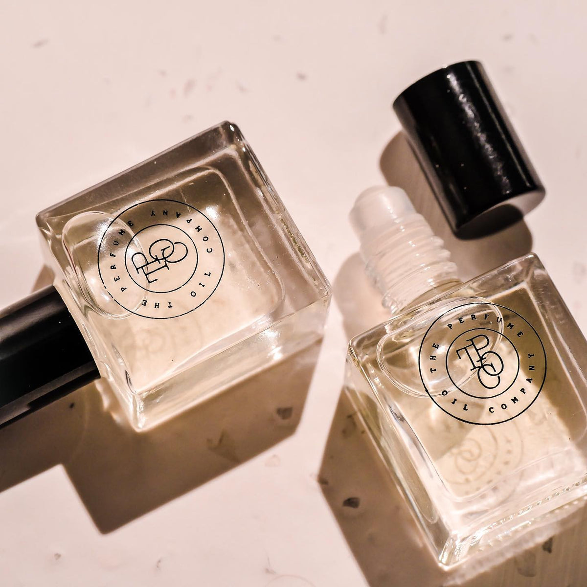 Two small bottles of NUDE perfume, inspired by Beige (CC), on a white surface.