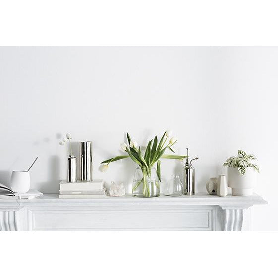 A white mantle with Zakkia clear glass Tapered Vases and books on it.