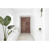 A white hallway with a wooden door and a Three Birds Renovations - 400+ Renovation and Styling Secrets Revealed book popular among renovators on YouTube and Instagram.