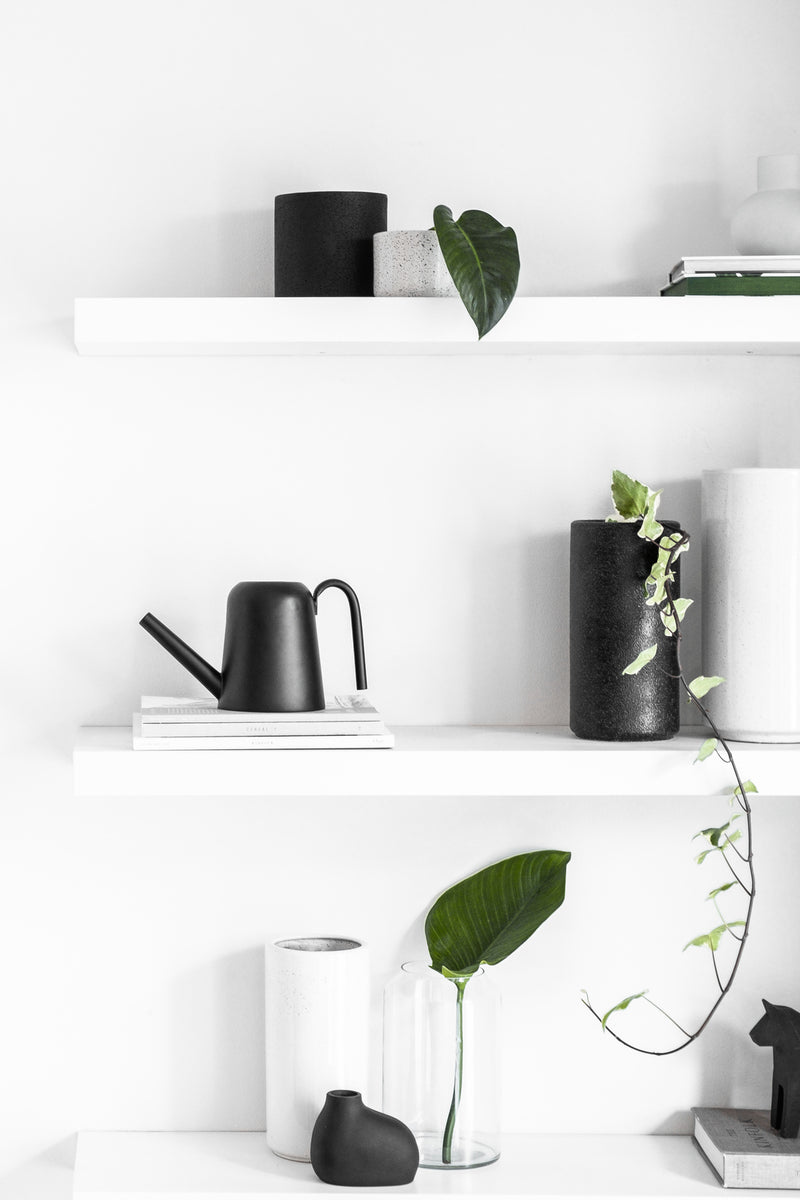 A white shelf with the Zakkia Embers Wall Planter - Large Charred vases, outdoor pots, and a plant.