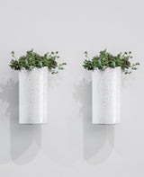 Two Embers Wall Planters - Small Ash by Zakkia, created using the reactive glaze process, are displayed on a white wall.