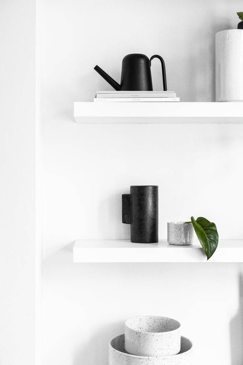 A unique Zakkia white shelf with black Embers Table Planter - Small Ash pots and bowls on it, featuring an organic finish.