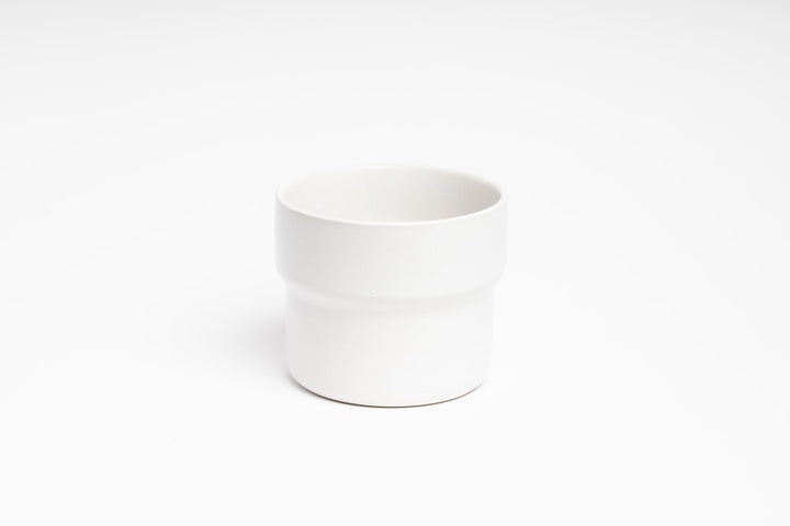 A white cup sitting on a white surface from Ned Collections' Eldi Pots.