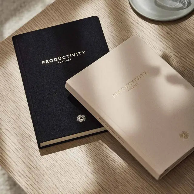 Two Intelligent Change Productivity Planners on a table next to a cup of coffee for 90-day planning.
