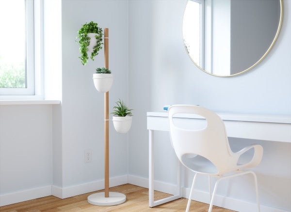 A room with an Umbra Floristand Planter - White/Natural adorned with pots.