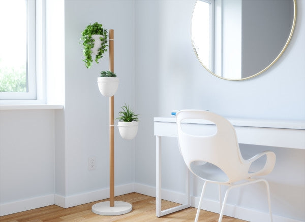 A room with an Umbra Floristand Planter - White/Natural adorned with pots.