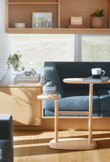 A multipurpose living room with a blue couch and an Umbra Swivo Side Table - Natural featuring swivelling table tops.