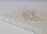 The Olive + Page Joy Journal for busy Mamas, placed on a white surface.