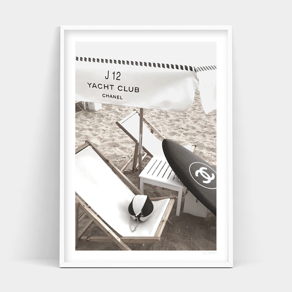 A black and white photo of a CHANEL CLUB beach chair and a surfboard by Art Prints.