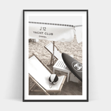 A black and white photo of a CHANEL CLUB beach chair and surfboard by Art Prints.