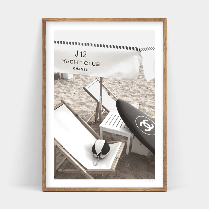 A black and white photo of a CHANEL CLUB beach chair and a surfboard by Art Prints.