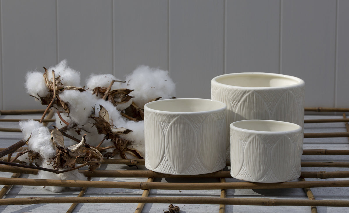 Three white Zakkia Kapok Pot vases on a bamboo mat.