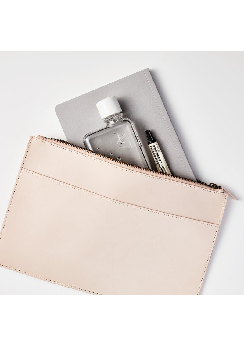 A compact pink leather pouch with an A7 Memobottle and a pen by MemoBottle.