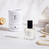 A bottle of SALT perfume next to a necklace and pearls, featuring the Designer Type Collection by The Perfume Oil Company, inspired by Wood Sage & Sea Salt (Jo Malone).