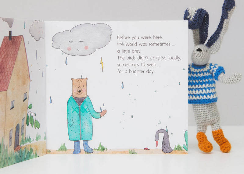 A children's book with a bunny in the rain called "BEFORE YOU WERE HERE" by Olive + Page.