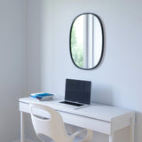 The Umbra range includes a white desk, complete with a laptop, and features the sleek Hub Mirror Oval - Black with a rubber rim.