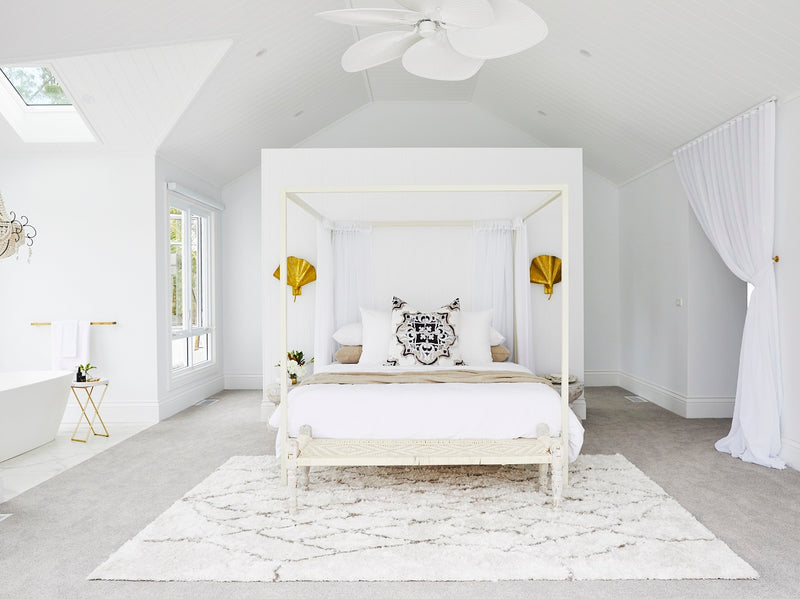 A white and gold bedroom with a canopy bed, perfect for book lovers, featuring the Three Birds Renovations: Dream Home How-To books.