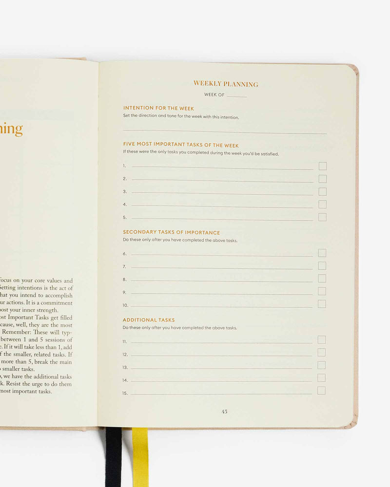 An open book with a yellow ribbon on it, serving as an Intelligent Change Productivity Planner to implement the focus time technique for effective 90-day planning.