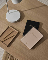 An Intelligent Change productivity planner on a wooden table next to a lamp.