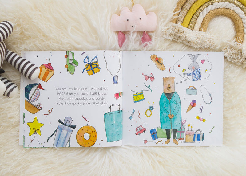A Olive + Page lifestyle book featuring BEFORE YOU WERE HERE, a teddy bear and a rainbow.