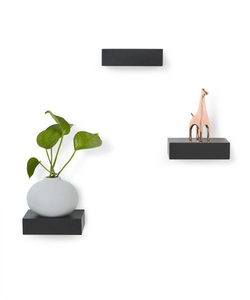 A Set (3) Showcase Shelves - Black by Umbra showcasing a giraffe and a plant.