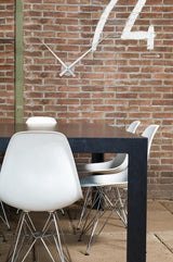 A table with chairs and a Karlsson Large Little Big Time Wall Clock - Silver on the wall.