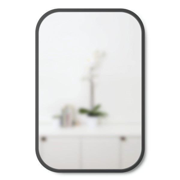 A Hub Mirror - Rectangle 61X91" Black adorned with a plant, made by Umbra.