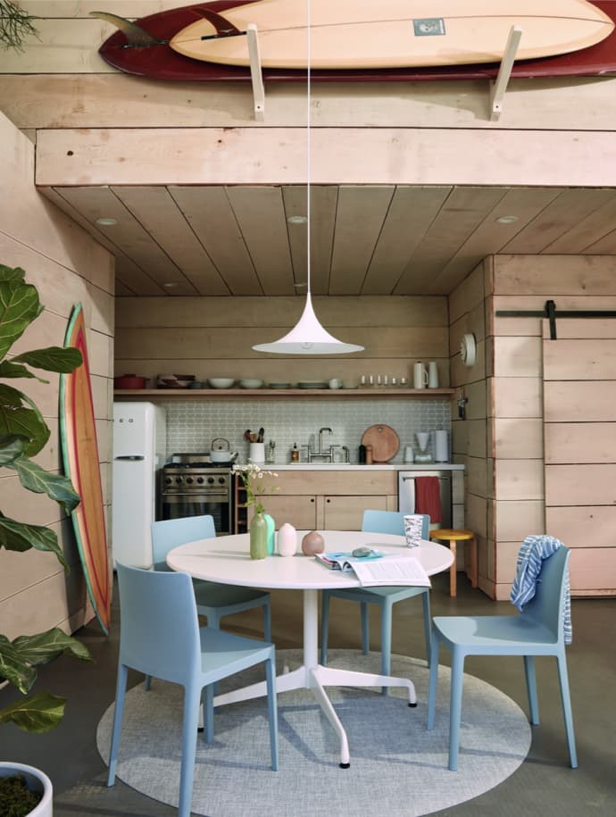 An artistic Surf Shacks Volume 2-inspired kitchen with a surfboard hanging from the ceiling, by Gestalten.