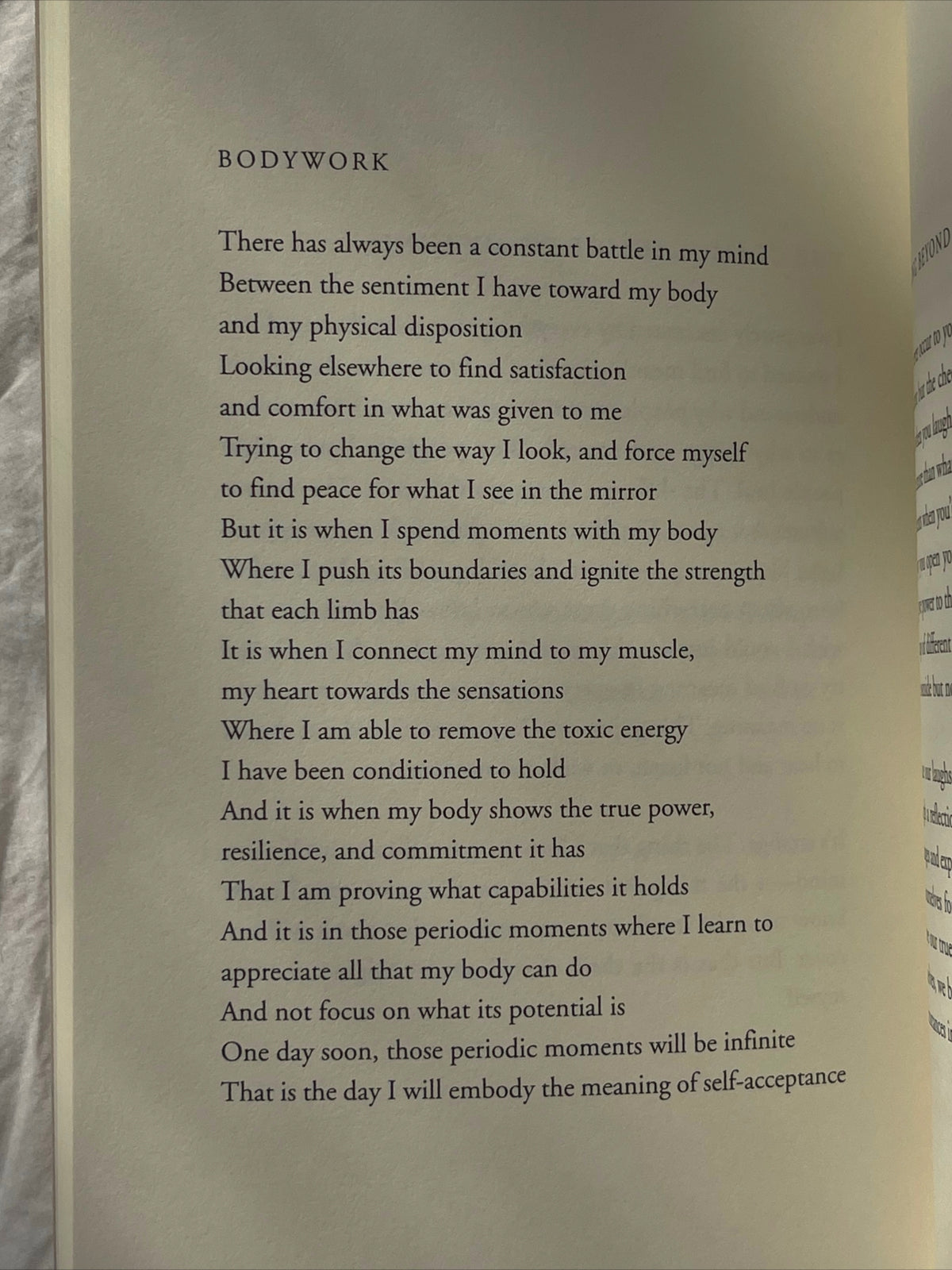 An open book with the poem "Beauty in the Stillness" by Thought Catalog on it.