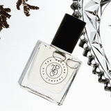 A bottle of NUDE perfume, inspired by Beige (CC), sitting next to a diamond ring from The Perfume Oil Company.