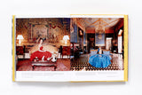A Slim Aarons: Women book with a woman in a dress sitting in a room.