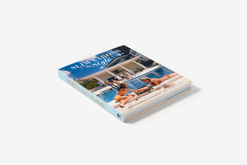 A Slim Aarons: Style book with a picture of a pool and two people on it.