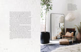 A page from the Curate by Lynda Gardener & Ali Heath book showcasing a room with plants and a mirror featuring vintage and modern pieces, home decorating, and a neutral palette.