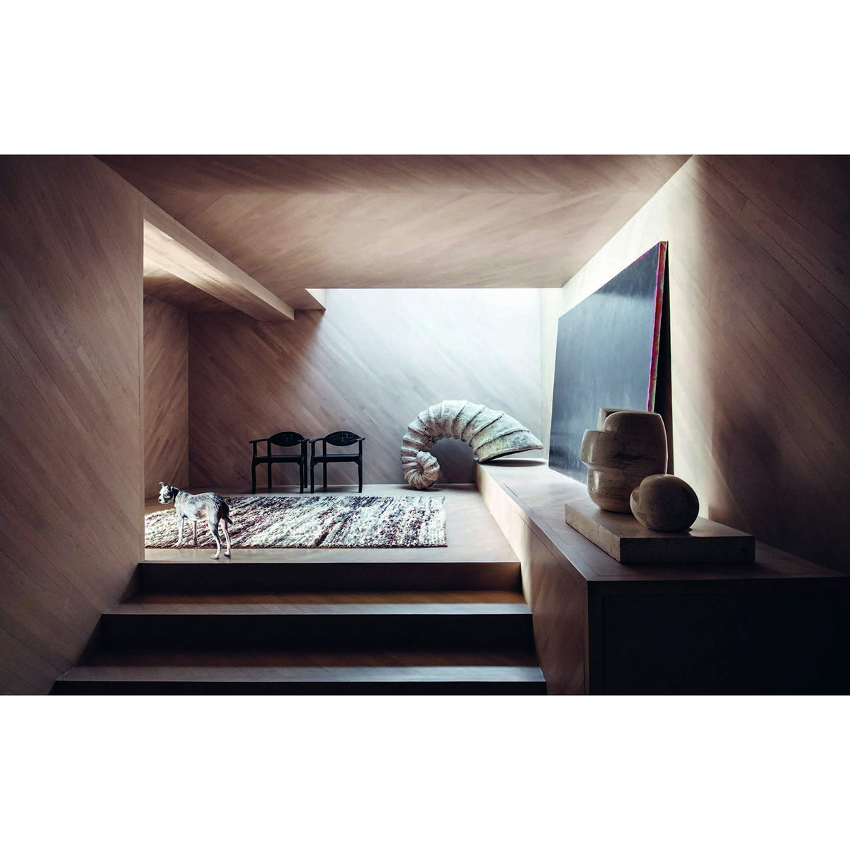 A room with Resident Dog Volume 2 | Nicole England by Books on the wooden floor and a chair.