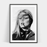 A black and white photo of a woman smoking a cigarette available for BARDOT Art Prints.