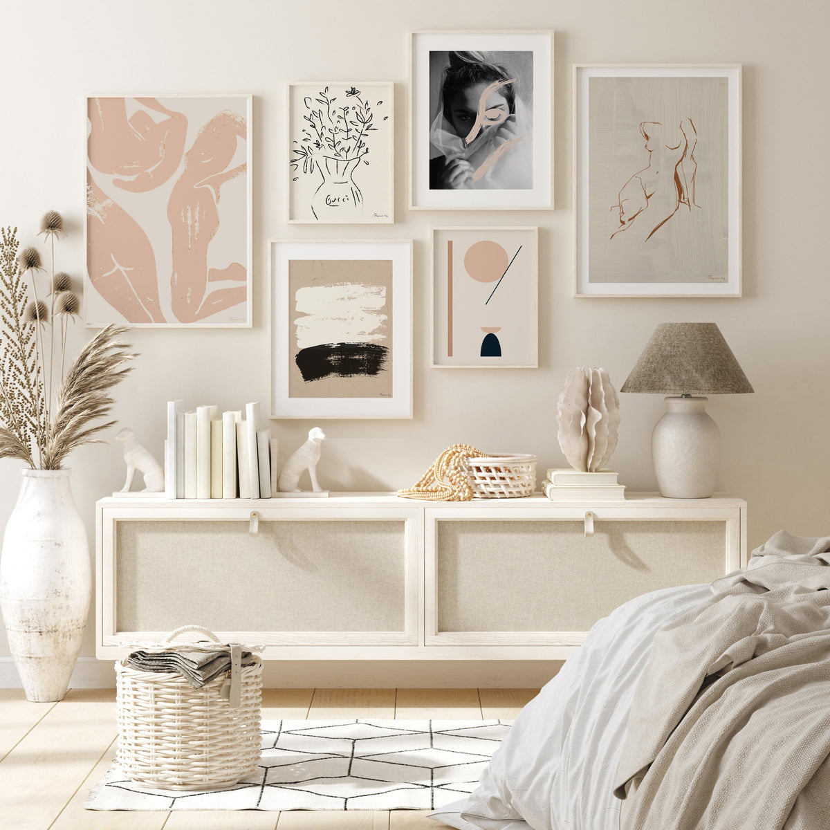 Figure print in a gallery wall above a white console by a bed