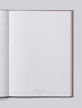 An open baby journal with blank pages for documenting the first five years from birth, available in grey, oatmeal, pink, or blue colors.