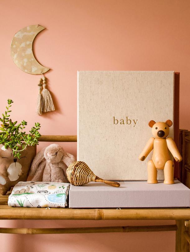 A baby gift box featuring a wooden box adorned with a cute teddy bear and perfect for nursery decor.