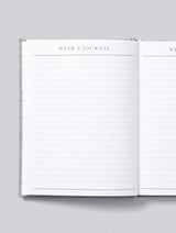 A white Bump - A Pregnancy Story notebook with the words week i journal on it, perfect for a baby shower gift.