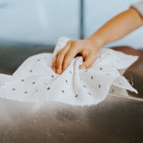A person using a Good Change Reusable Bamboo Towel to clean a cloth in a sink.