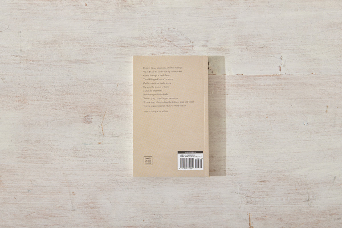 The back of a Beauty in the Stillness notebook sitting on a wooden surface.